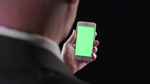 Elegant Man in a suit Using a Smart Phone with Green Screen on the black back Stock Footage 133004615