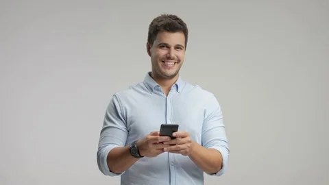 Elegant man using a phone and smiling 스톡 동영상 77753129