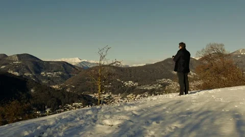 Elegant Man Using Smartphone and Making Photos and Joy Mountain View with Snow Stockbeeldmateriaal 191953524