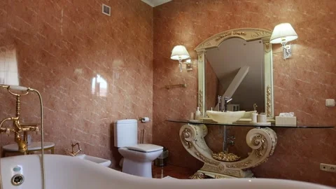 Elegant marble bathroom interior with ornate mirror, bathtub, vanity, toilet Vídeos de archivo 337937500