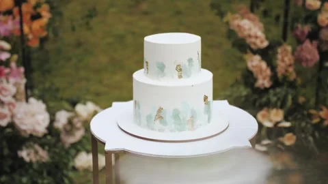 Elegant multi-tiered wedding cake with beautiful floral ornament. Cake near the Stock Footage 307292940