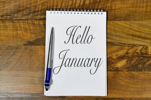 Elegant Notebook Displaying the Message 'Hello January' on a Wooden Desk Stock Photos