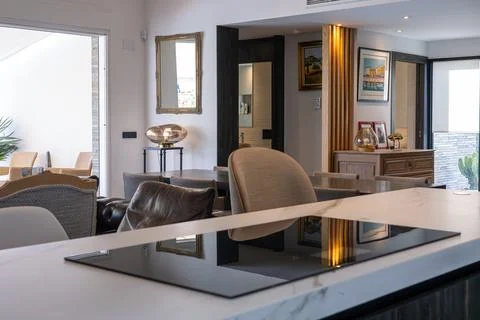 Elegant open-plan interior with marble kitchen island, vintage decor, and p.. 스톡 사진