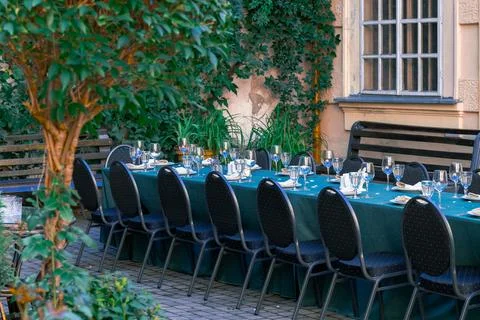 Elegant outdoor dining table set for a special event with glassware and chair Stock Photos