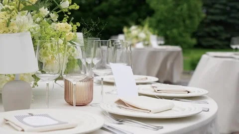 Elegant Outdoor Event Table Setting with White Flowers and Fine Tableware Stock Footage 338072762