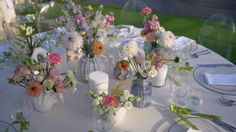 Elegant Outdoor Table Setting with Fresh Floral Centerpieces in Daylight Stock Footage 345234651