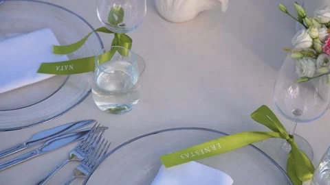 Elegant Outdoor Table Setting with Glass Plates, Green Ribbon Place Cards, and Stock Footage 345235116