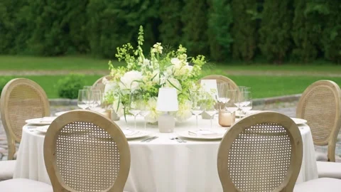 Elegant Outdoor Wedding Table Setting with Floral Centerpiece and Soft Natural Stock Footage 338166363