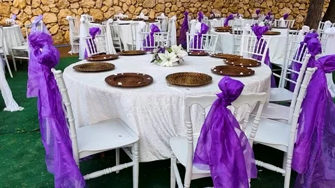 Elegant outdoor wedding table setup with purple ribbons and wicker plates Stock Footage 330209419