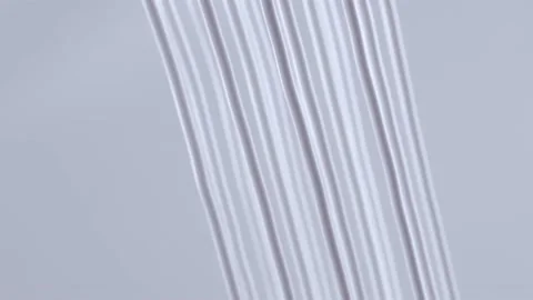 Elegant parallel strings of white cream in mid air Stock Footage 219492005