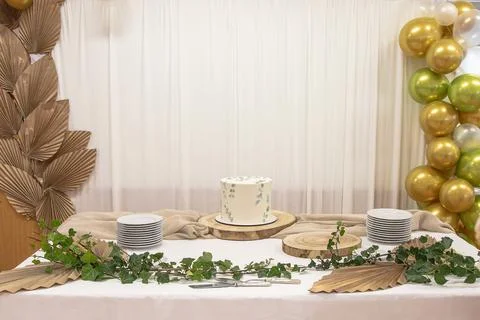 Elegant party table set for a daytime celebration, with a white cake centerpiece Stock Photos