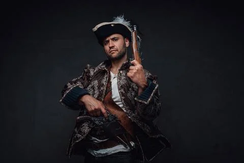 Elegant pirate with boarding pistols and serious face Stock Photos