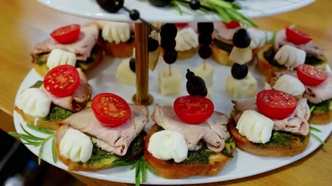 Elegant platter displaying roasted beef, cherry tomatoes, pesto, cheese, olive Stock Footage 331464069