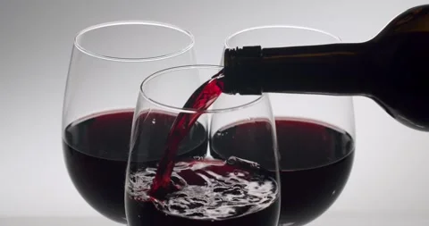 Elegant red wine pouring from bottle into a glass Stock Footage 342737053