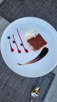Elegant restaurant dessert presentation featuring a slice of tiramisu with wh Stock Photos