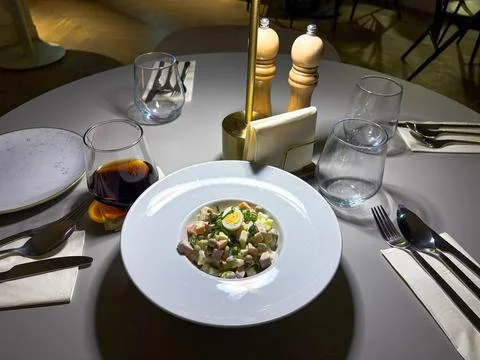 Elegant restaurant table setting featuring a plated classic salad with eggs Foto stock
