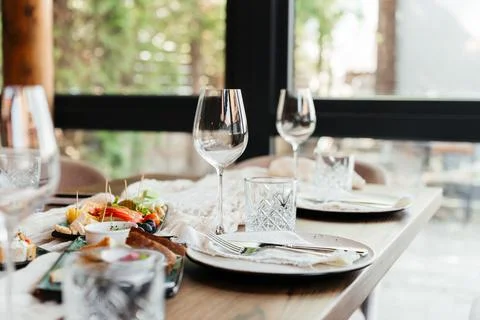 Elegant restaurant table setting with glassware and plates in a bright, modern Stock Photos