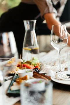 Elegant restaurant table setting with glassware and plates in a bright, modern Stock Photos