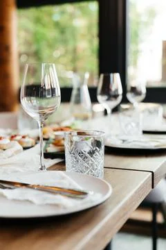 Elegant restaurant table setting with glassware and plates in a bright, modern Stock Photos