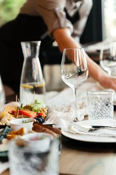 Elegant restaurant table setting with glassware and plates in a bright, modern Stock Photos