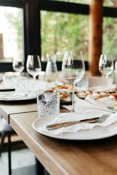 Elegant restaurant table setting with glassware and plates in a bright, modern Stock Photos