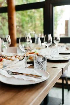 Elegant restaurant table setting with glassware and plates in a bright, modern Stock Photos