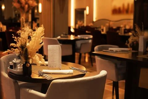 Elegant restaurant table setting with menu, cutlery and dried flowers in va.. Foto stock