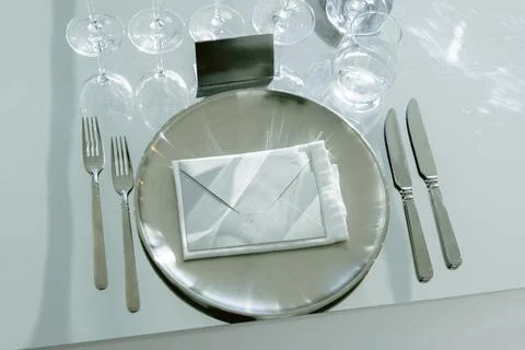 Elegant restaurant table setting with plates cutlery and crystal glasses Stock Photos