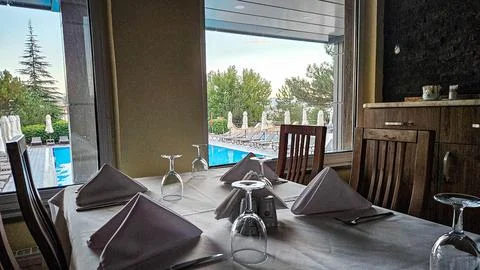 Elegant restaurant table by window with pool view Stock Photos