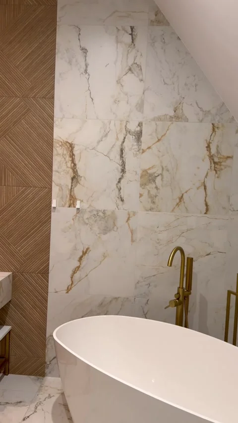 Elegant restroom interior features beautiful ceramic tile with golden marble Stock Footage 344553760