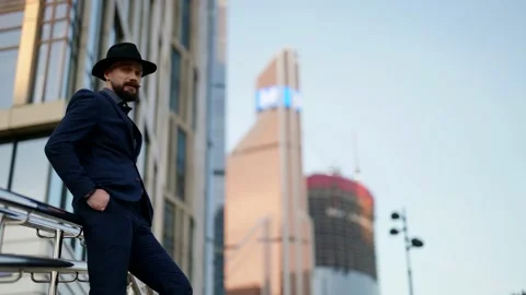 Elegant retro dressed man is posing against modern urbanistic landscape with Video stock 166092889