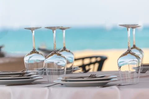 Elegant seaside restaurant table setting with upside down wine glasses and .. Stock Photos