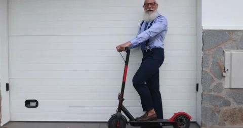 Elegant senior hipster man using electric push scooter Stock Footage 153403493