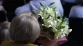 Elegant senior lady watching concert, holding bunch of beautiful lilium flowers HD Footage