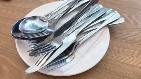 Elegant Silverware and Clean Cutlery Set on a White Dining Plate Stock Footage 332782252