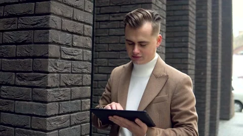 Elegant smiling man with tablet looking at camera 스톡 동영상 144062564