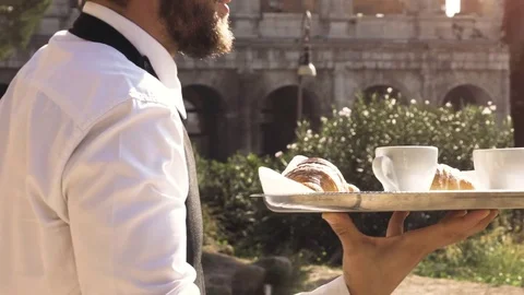 Elegant smiling waiter serving breakfast with breakfast coffee croissant Video stock 85330635