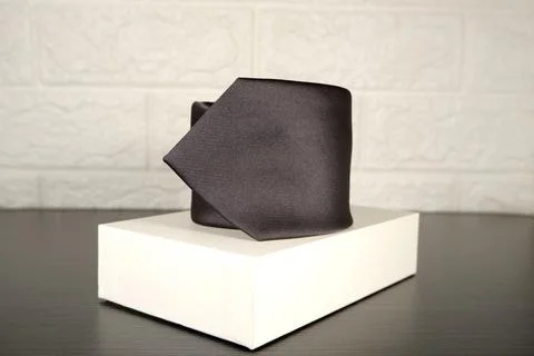 Elegant solid striped blue polyester fabric necktie rolled over white background Stock Photos