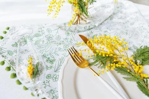 Elegant spring dining table with mimosa flowers and champagne glass Foto stock