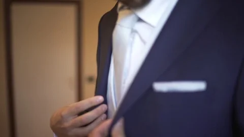 Elegant stylish man buttoning the blue jacket of his suit. 動画素材 74805052