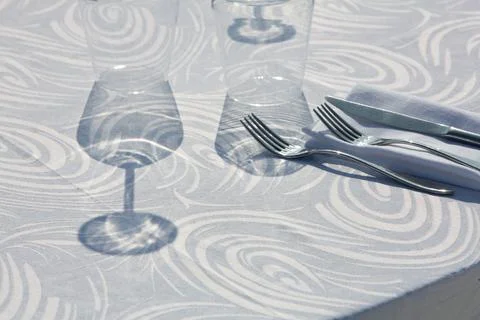 Elegant table setting casting shadows on a textured tablecloth 스톡 사진