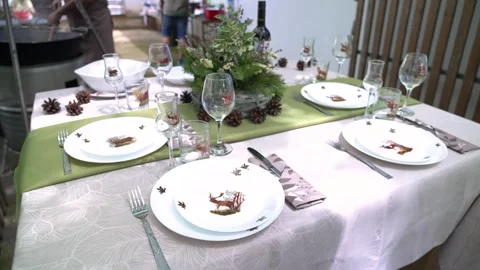 Elegant table setting with deer decorations for a rustic hunting-themed dinner Stock Footage 346186580