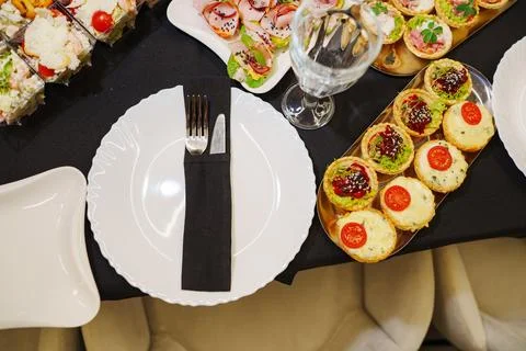 Elegant table setting with empty white plate and luxury catering snacks Stock Photos
