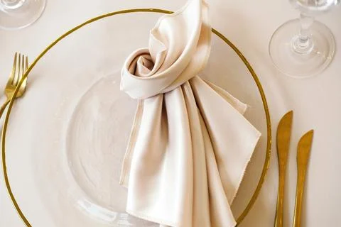 Elegant table setting featuring a clear glass plate with a golden rim, adorned Stock Photos