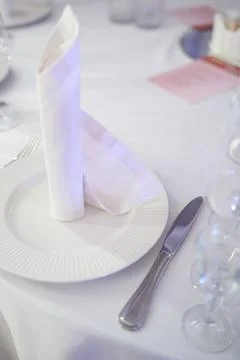 Elegant table setting with folded napkin on white plate and silverware Stock Photos