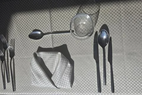 Elegant Table Setting With Folded Napkin, Silverware and Glass Cast in Stro.. Stock-Fotos