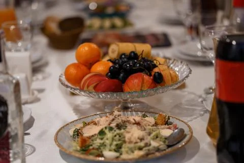 Elegant Table Setting with Fresh Fruit Platter and Caesar Salad in Glass Bo.. Stock Photos