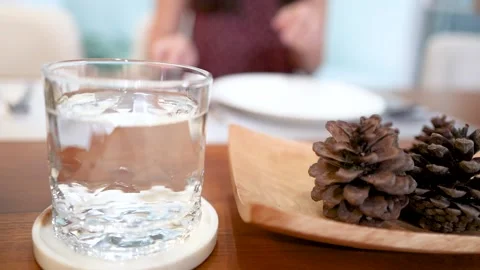 Elegant table setting with glass of water and decorative pine cones Stock Footage 334983614