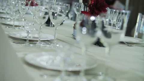 Elegant table setting with glassware and red flowers Stock Footage 312513083