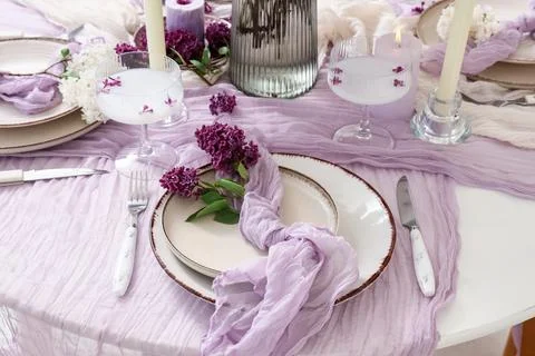 Elegant table setting with lilac flowers and purple runner for a wedding or s Stock Photos